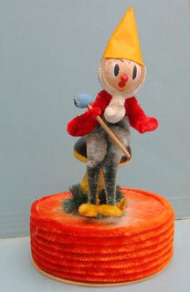 22b: An elf sitting on a mushroom is about 19cm high. No indication of origin. All different colored chenille; the inside of the box is plain cardboard.