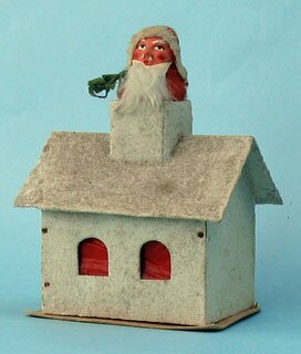 60: Santa, plaster face, rabbit fur beard, paper tree, in the chimney of a wooden house, covered with glitter, candy container, walls are of wood, roof and base of cardboard, 9cm x 13cm high